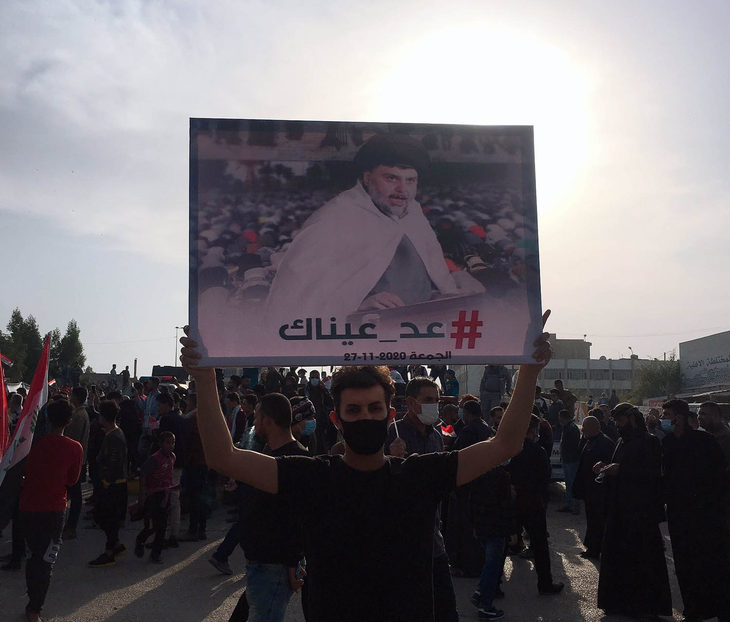 متظاهر عراقي يرفع راية تأييد لمقتدى الصدر