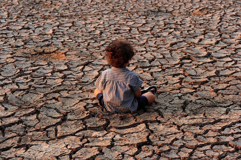 طفل في هندوراس يجلس في منطقة تضررت من الجفاف