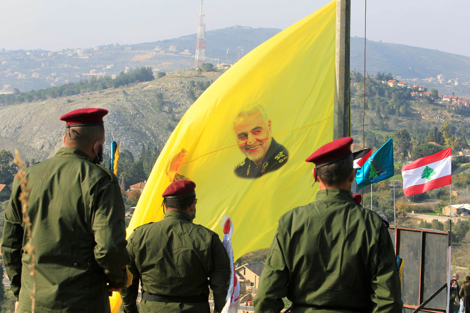 مقاتلون من حزب الله يرفعون صورا لقاسم سليماني على اعلام الحزب بالقرب من الحدود اللبنانية الاسرائيلية