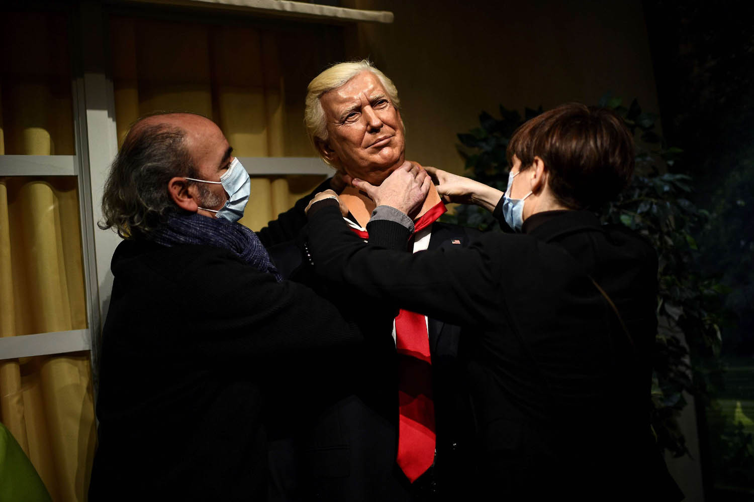 موظفون في متحف الشمع في باريس يفككون تمثالا للرئيس الأميركي دونالد ترامب