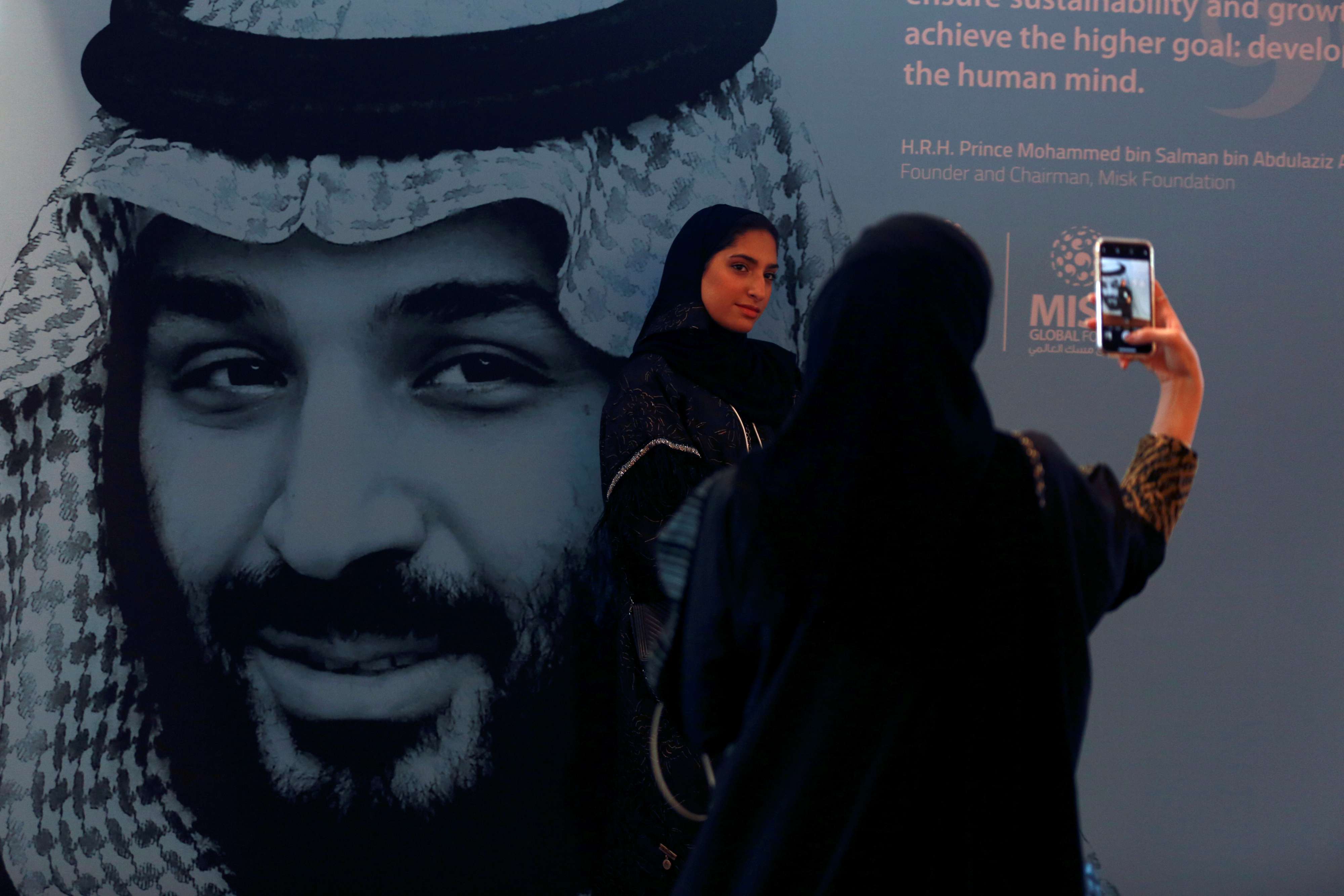  سعوديات يلتقطن صوراً بجوار صورة ولي العهد السعودي الأمير محمد بن سلمان خلال منتدى مسك العالمي في الرياض 