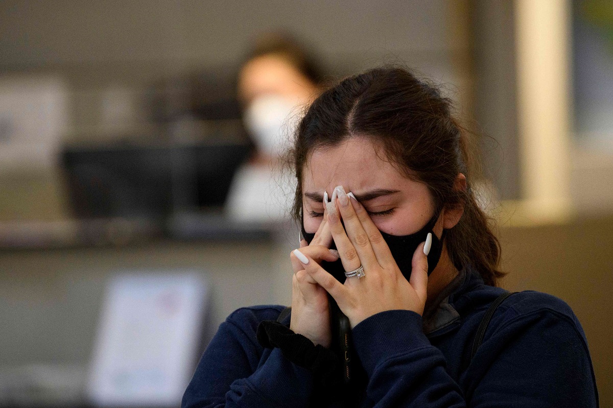 فتاة أميركية تبكي أحد أقاربها المتوفي جراء الاصابة بكورونا