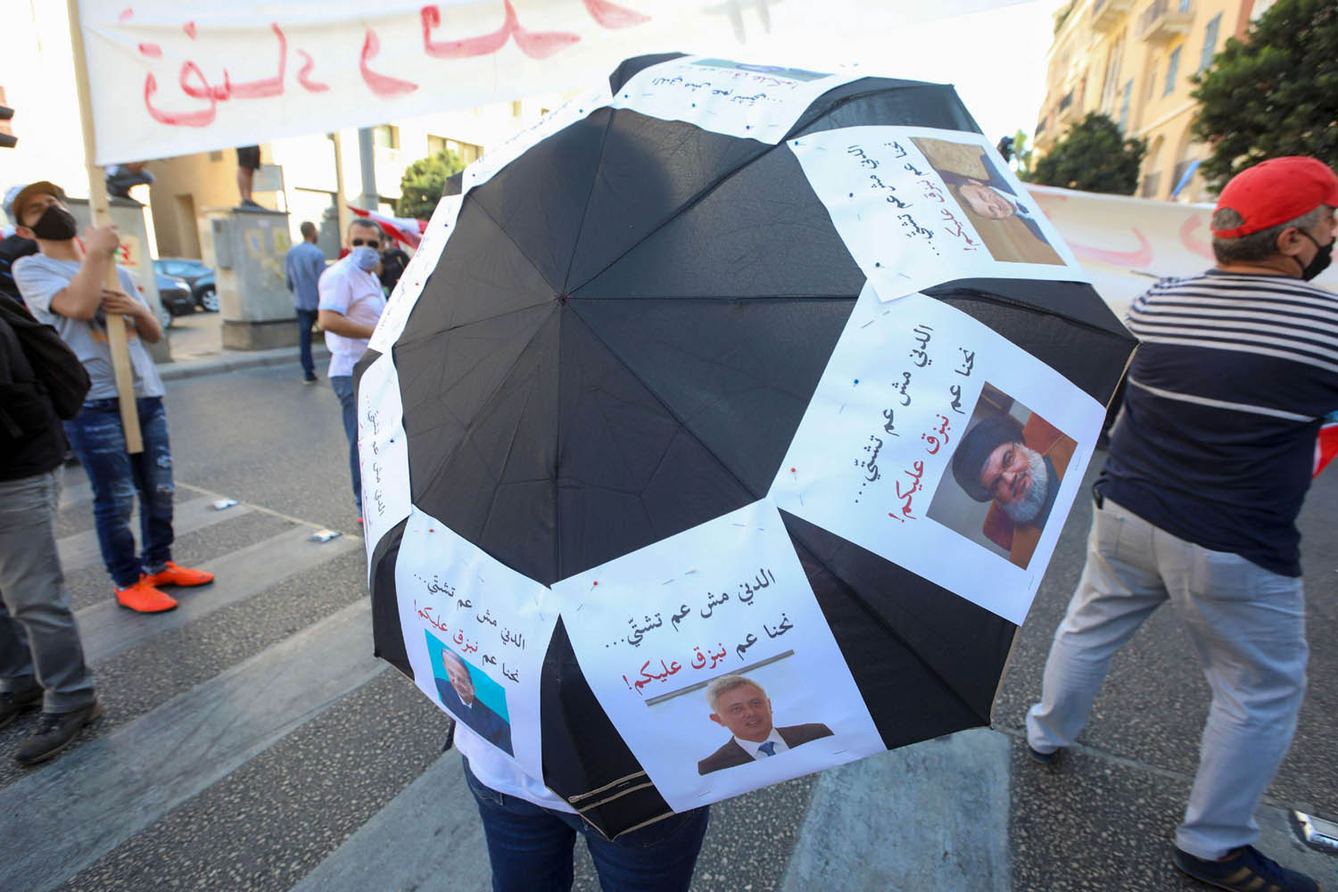 محتج لبناني في بيروت يستعرض صورا للطبقة السياسية الحاكمة