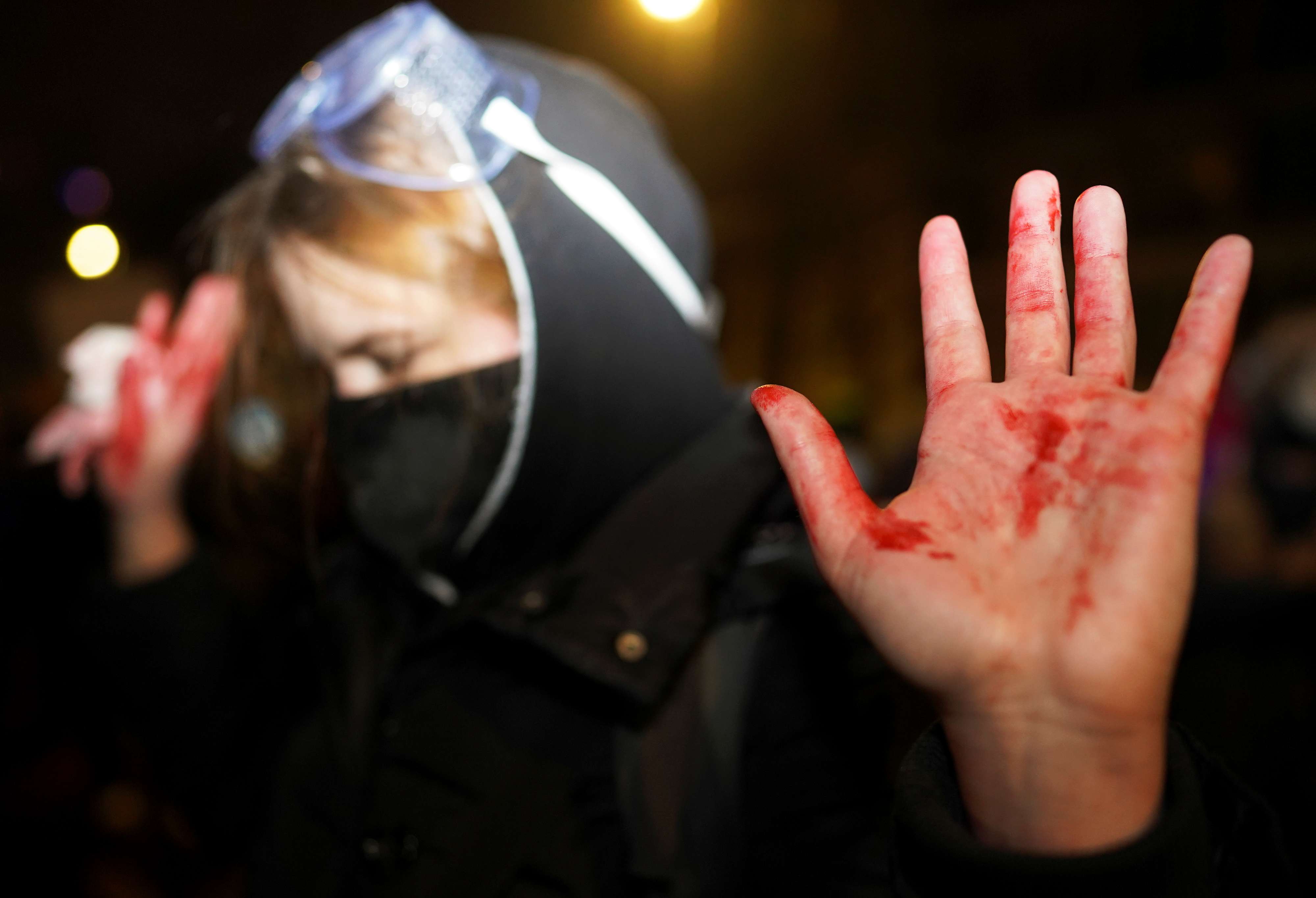 متظاهرة تغطي يديها بالطلاء الأحمر خلال احتجاج على حكم يقيد حقوق الإجهاض في بولندا