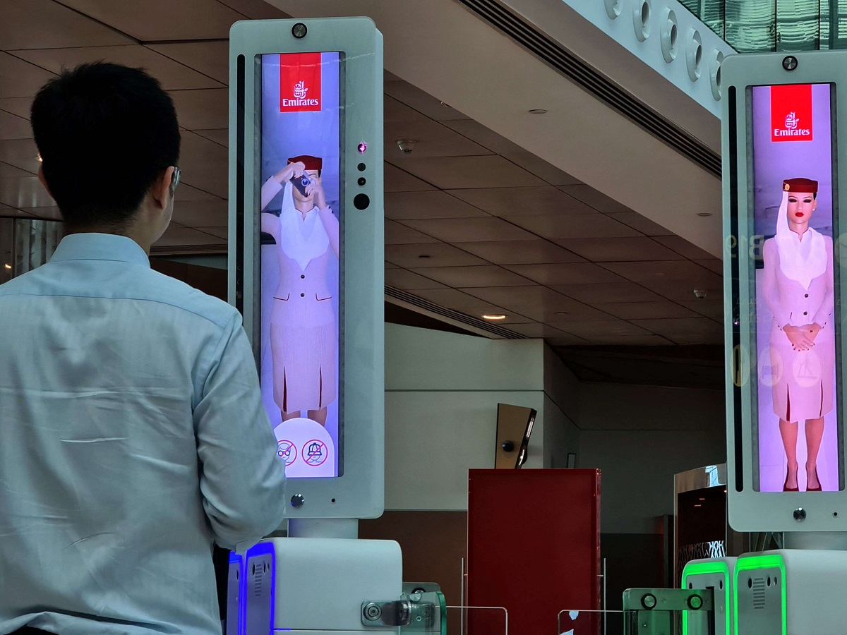 مسافر يعبر بوابة المسار السريع التي تستخدم تقنيات جديدة في مطار دبي الدولي
