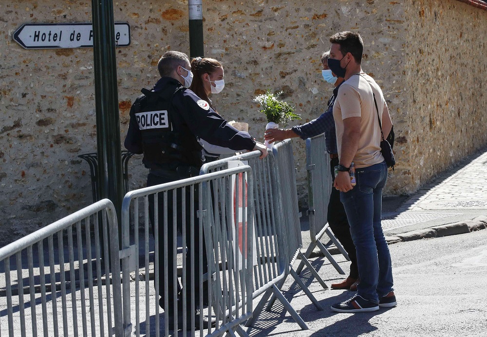 مواطن فرنسي يقدم باقة ورد لشرطية بعد مقتل زميلتها طعنا