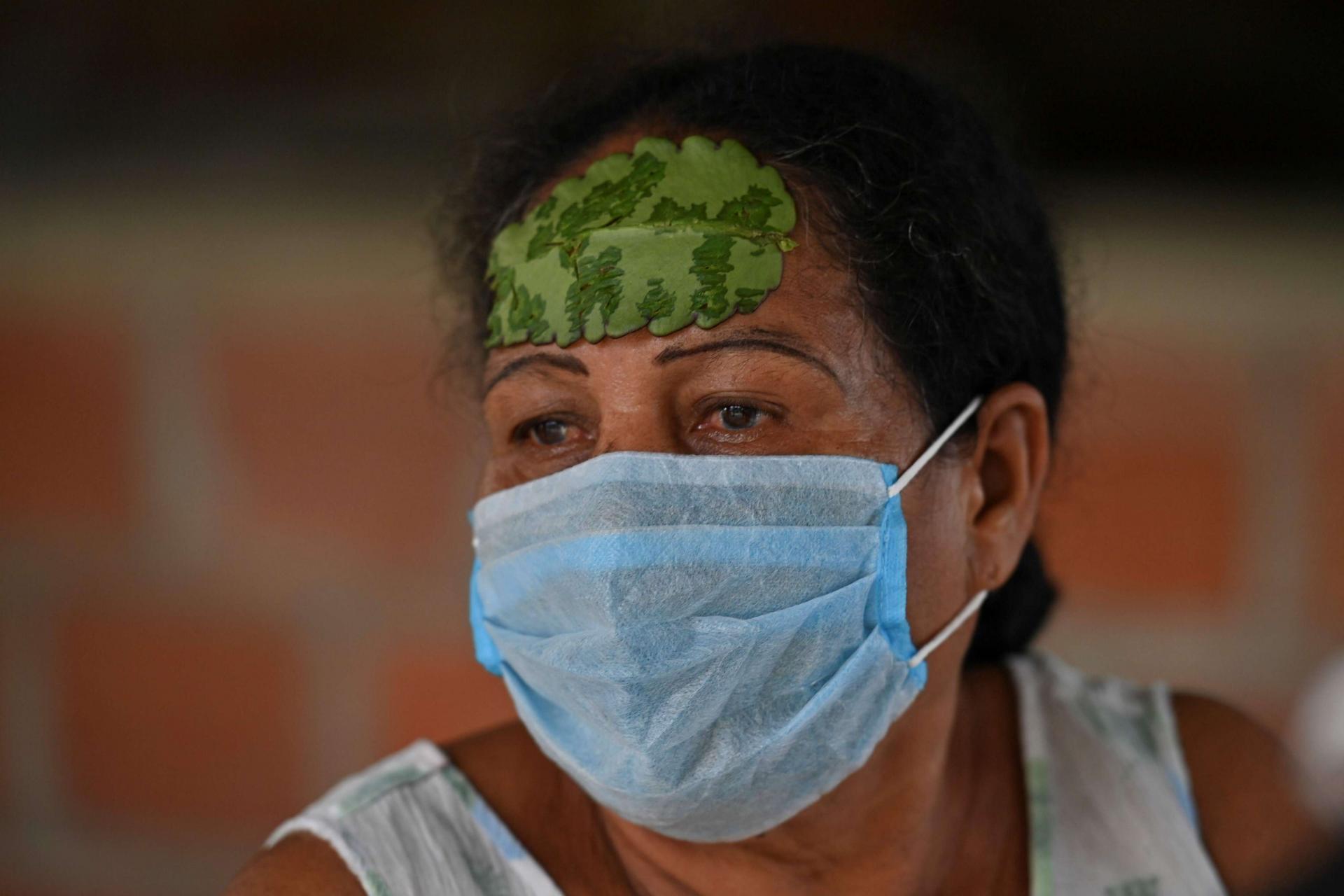 امرأة كولومبية تضع على جبينها ورقة شجر لعلاج الصداع
