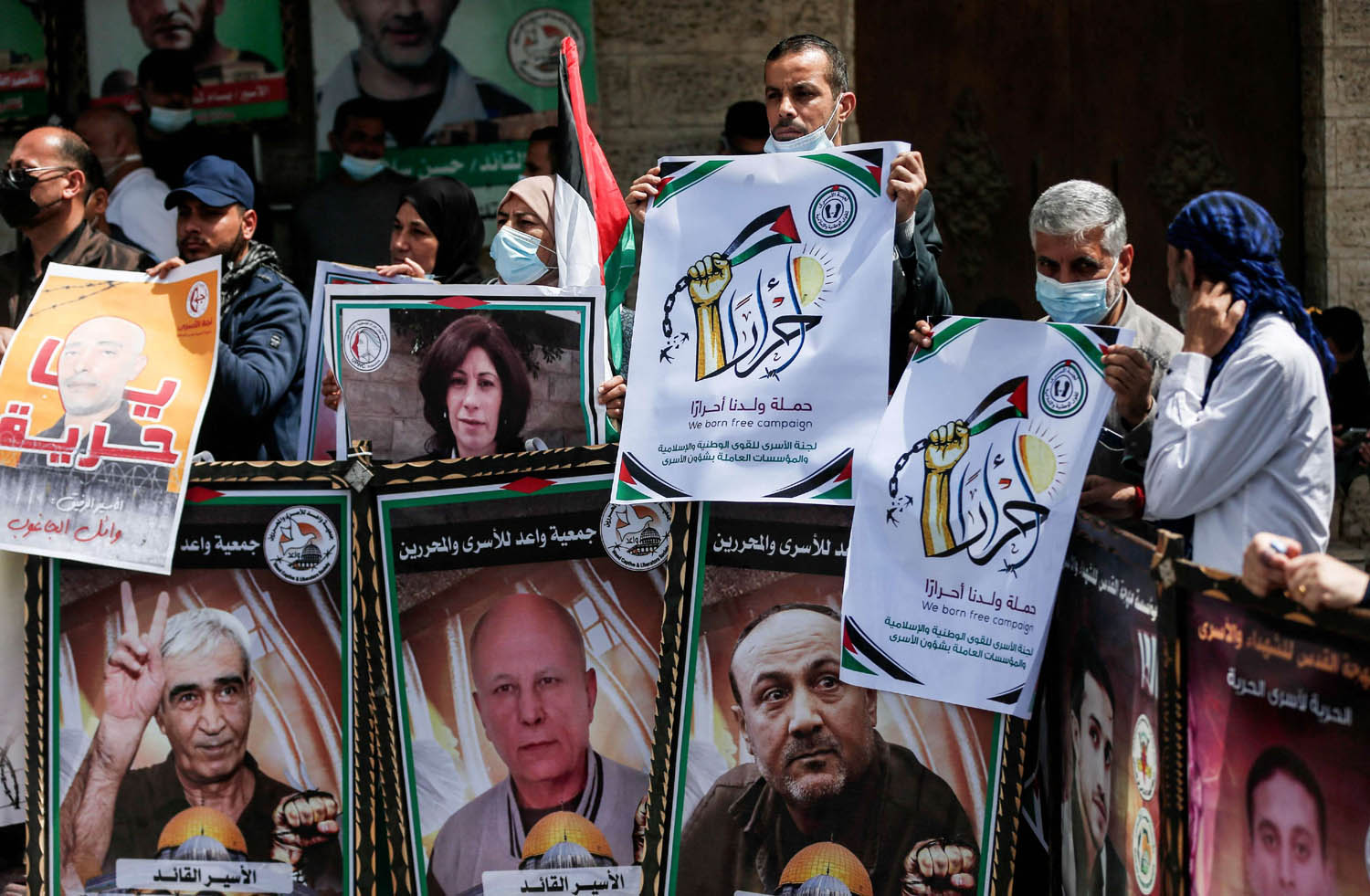 فلسطينيون يرفعون صورا لأسرى من زعماء الحركات الفلسطينية