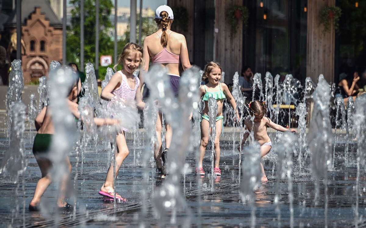 أطفال يلعبون بالماء في يوم ربيعي حار في موسكو