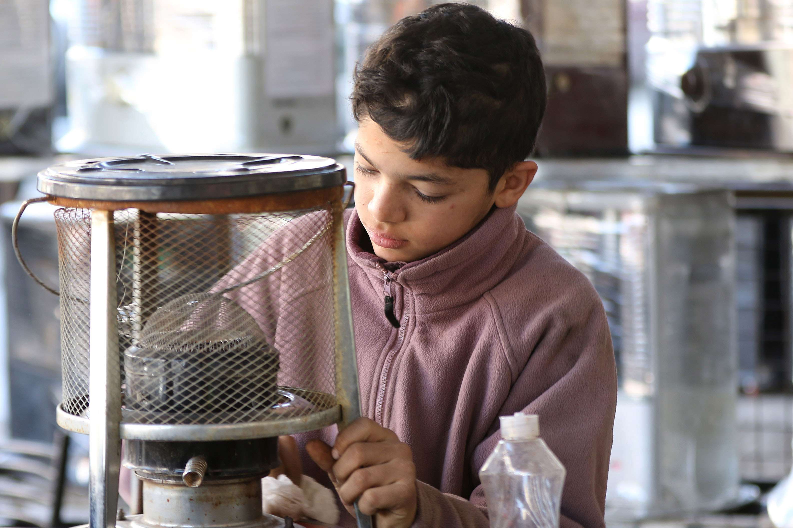 طفل أردني يعمل في ورشة إصلاح للمدافئ في عمان
