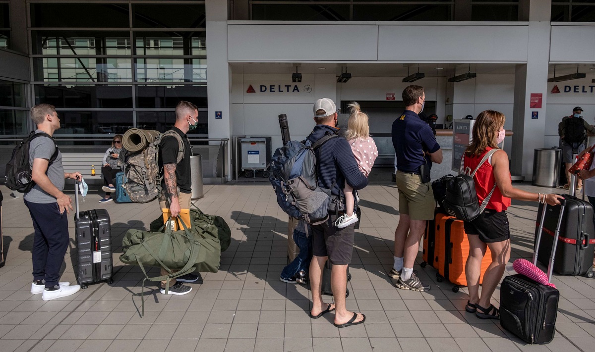 مسافرون ينتظرون في طابور في مطار  ديترويت بميشيغان في الولايات المتحدة