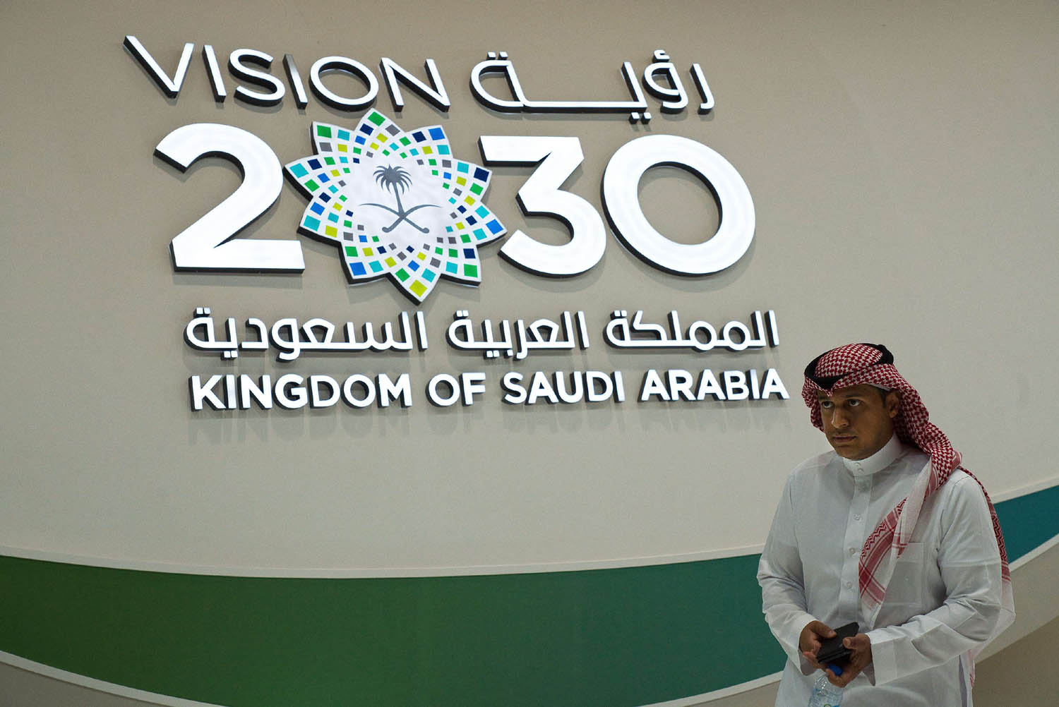 سعودي أمام جدارية لـ"رؤية 2030"