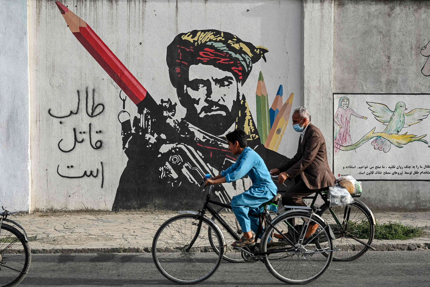 أفغان يمرون من أمام جدارية عن طالبان