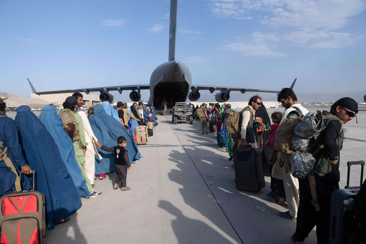 افغان يستعدون لركوب طائرة عسكرية أميركية في مطار كابول