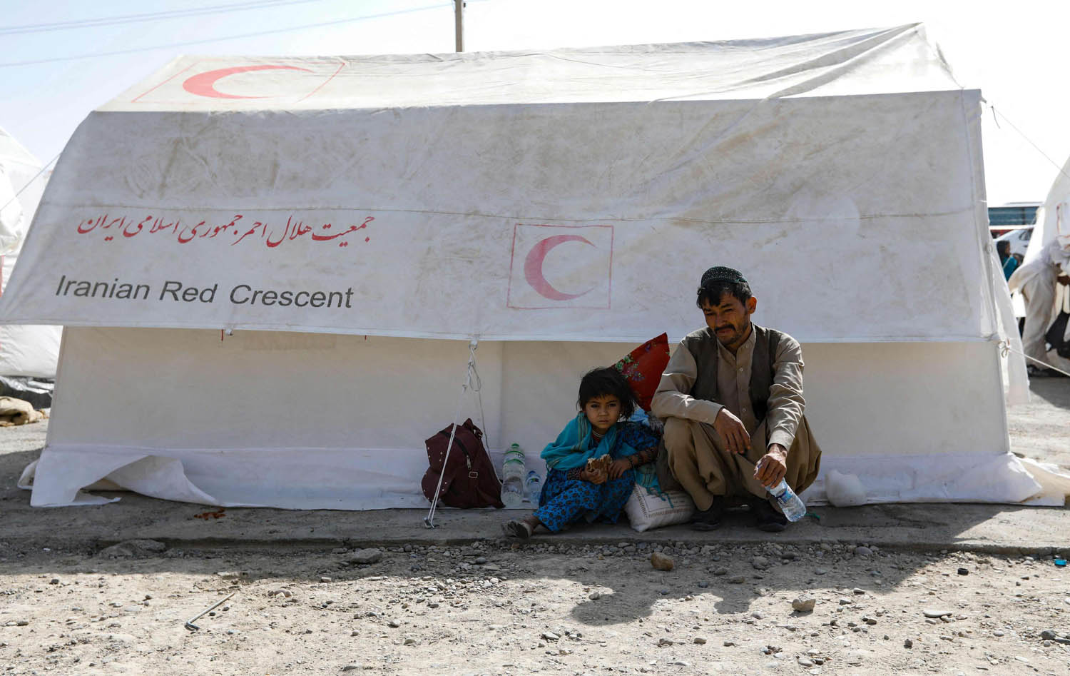 أفغاني وابنه في خيمة للهلال الاحمر الايراني