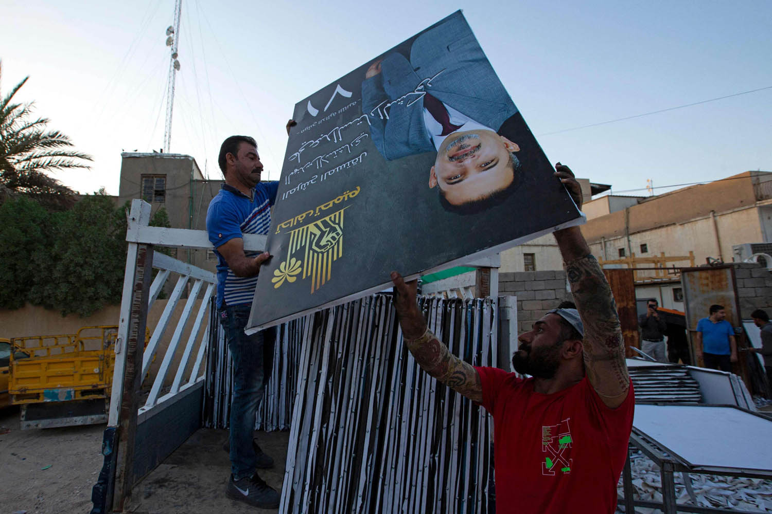 عمال يوزعون لافتات لمرشحين عراقيين في البصرة