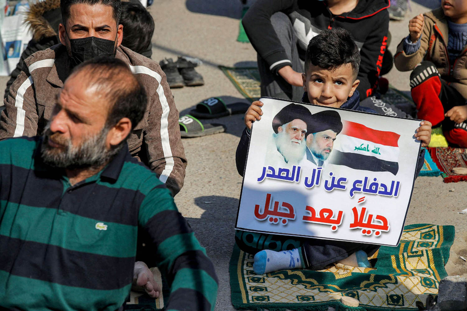 طفل عراقي يرفع لافتة تأييد لمقتدى الصدر