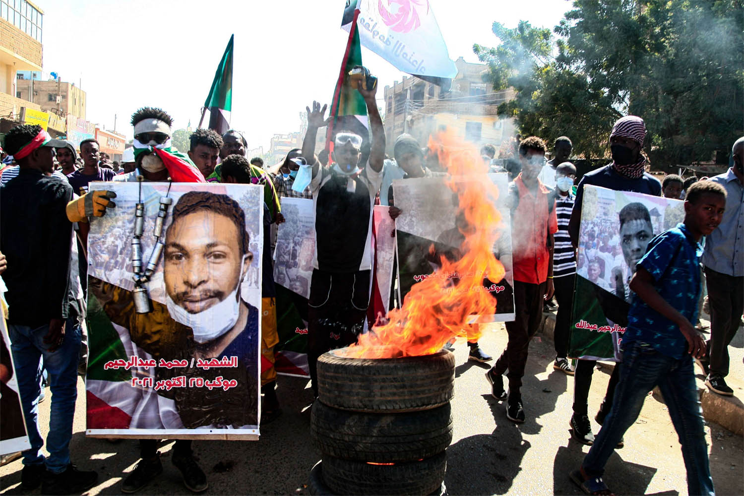 Sudanese demonstrators carry posters of killed protesters as they protest in Khartoum 
