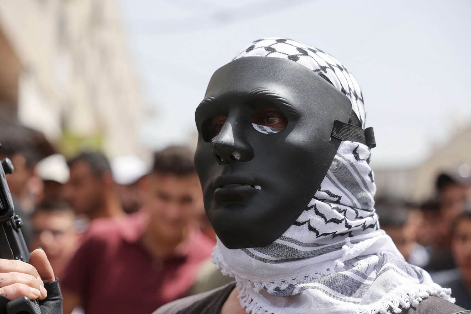 فلسطيني يرتدي قناعا في تشييع قتلى هجوم إسرائيلي في الضفة الغربية