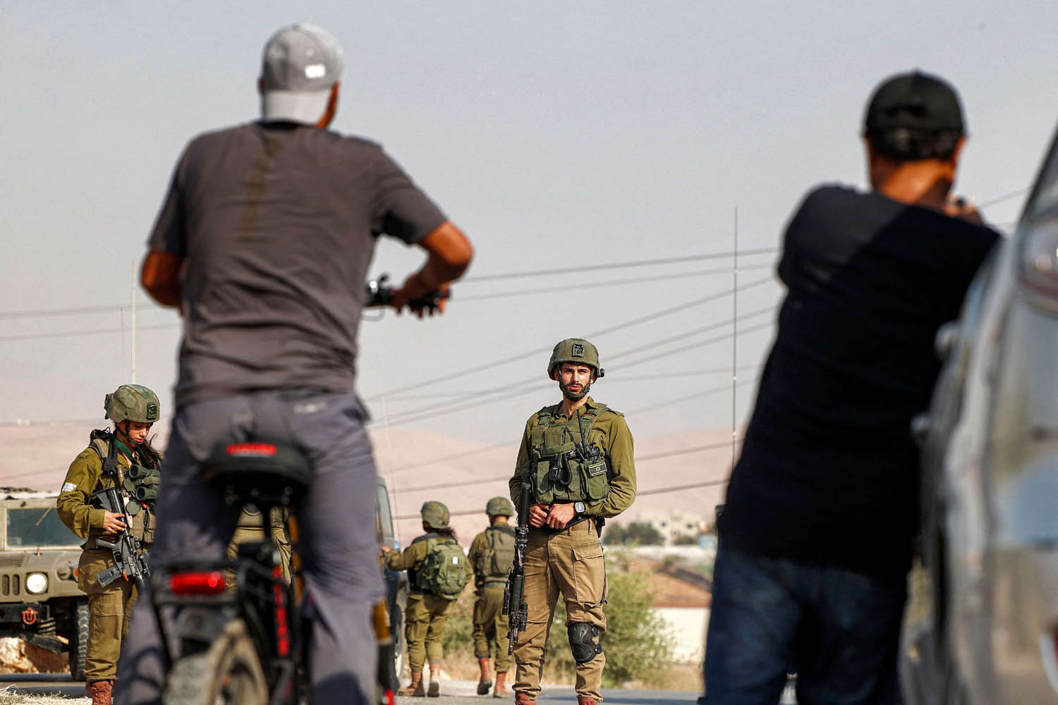 جنود إسرائيليون يمنعون فلسطينيين من المرور في طريق بالقرب من القدس