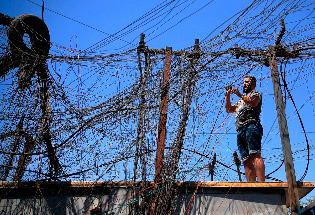 عراقي وسط شبكة توزيع كهرباء خاصة في بغداد