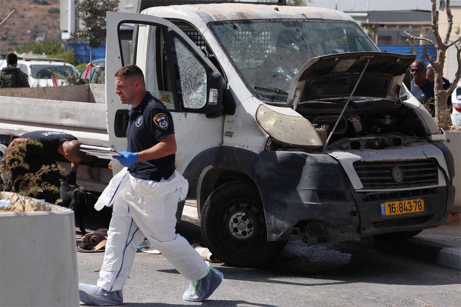 Israeli forensic inspect a truck next to a checkpoint outside the Palestinian village of Nilin