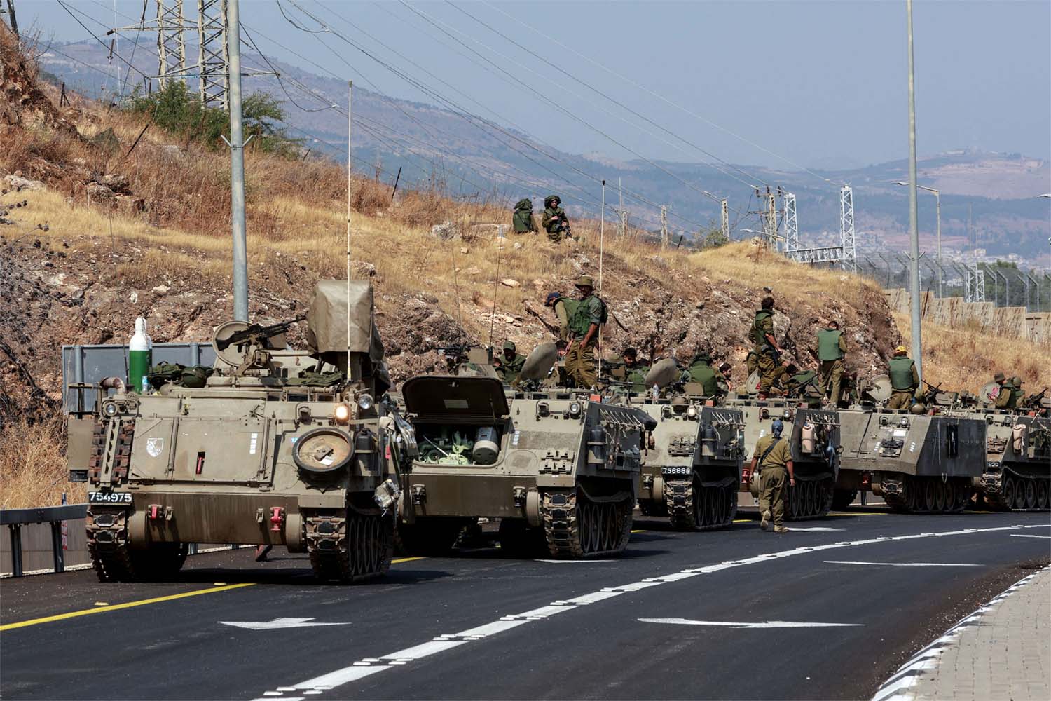 A convoy of Israeli Armoured Personnel Carriers drives on a road near Israel's border with Lebanon
