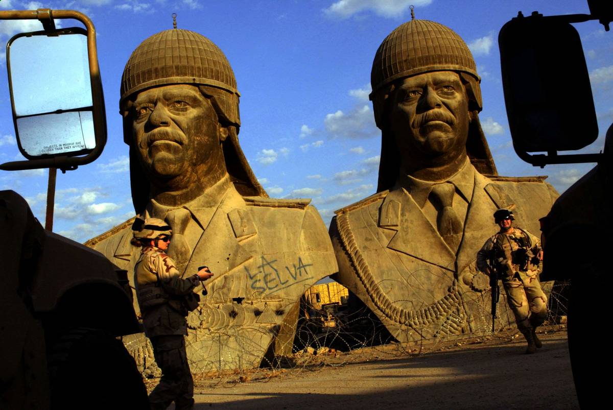 جنود أميركيون مع تماثيل للرئيس العراقي صدام حسين