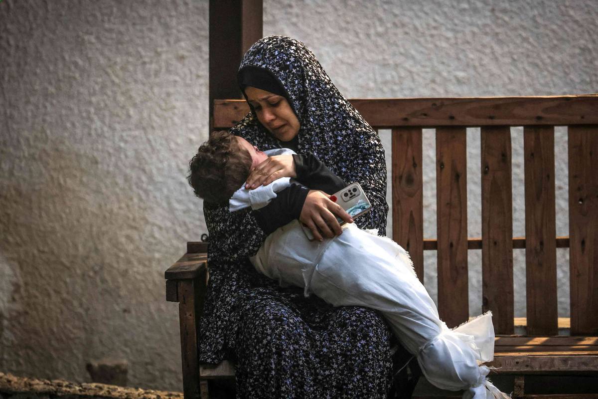 فلسطينية من عائلة عاشور تحتضن ابنها الذي قتل في قصف إسرائيلي لرفح