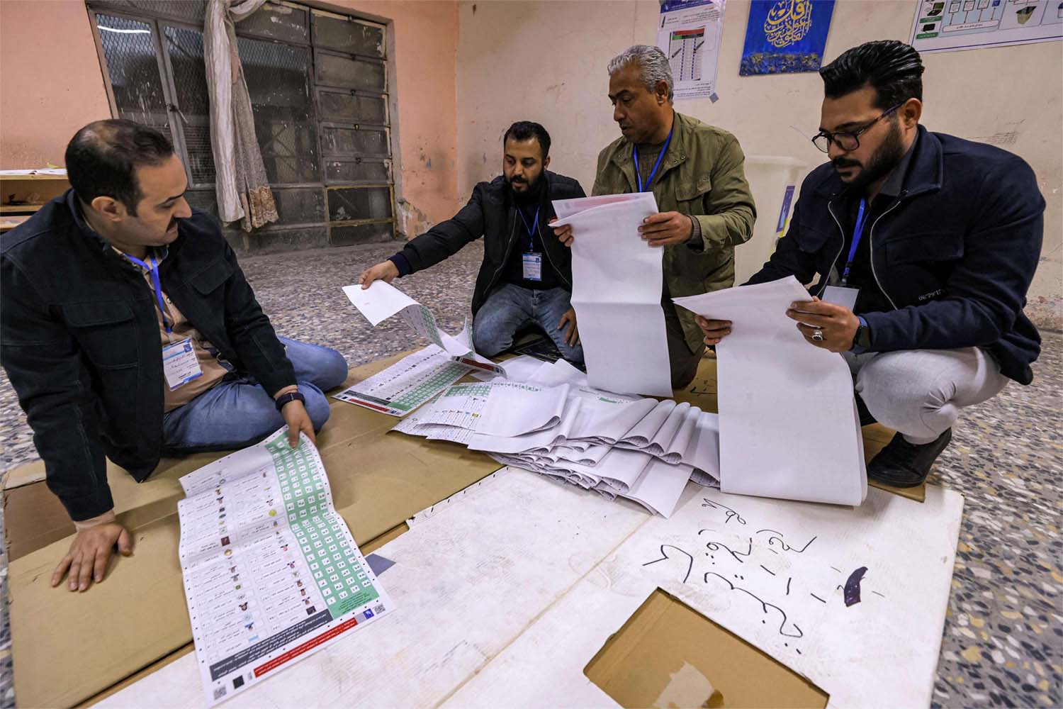 Election Commission employees count ballots at a polling station in Sadr City in eastern Baghdad 