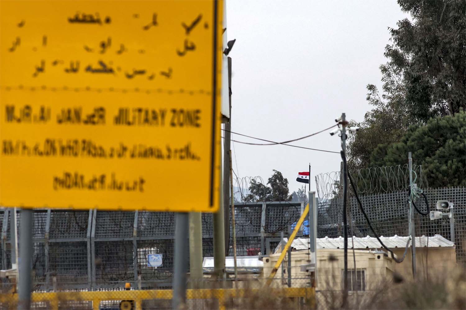 A Syrian flag flies at the Quneitra checkpoint across the fence separating the Israeli-annexed Golan Heights from Syria