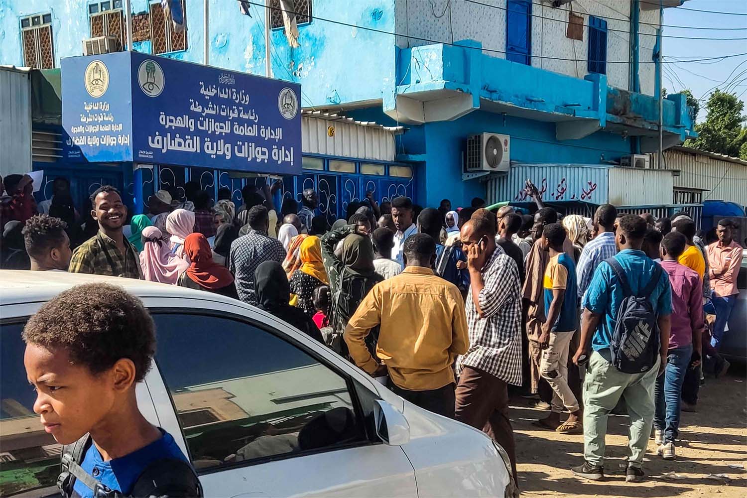 People displaced by war in Sudan gather outside a passport office in city of Gedaref as they attempt to get passports and exit visas after fleeing flee Wad Madani
