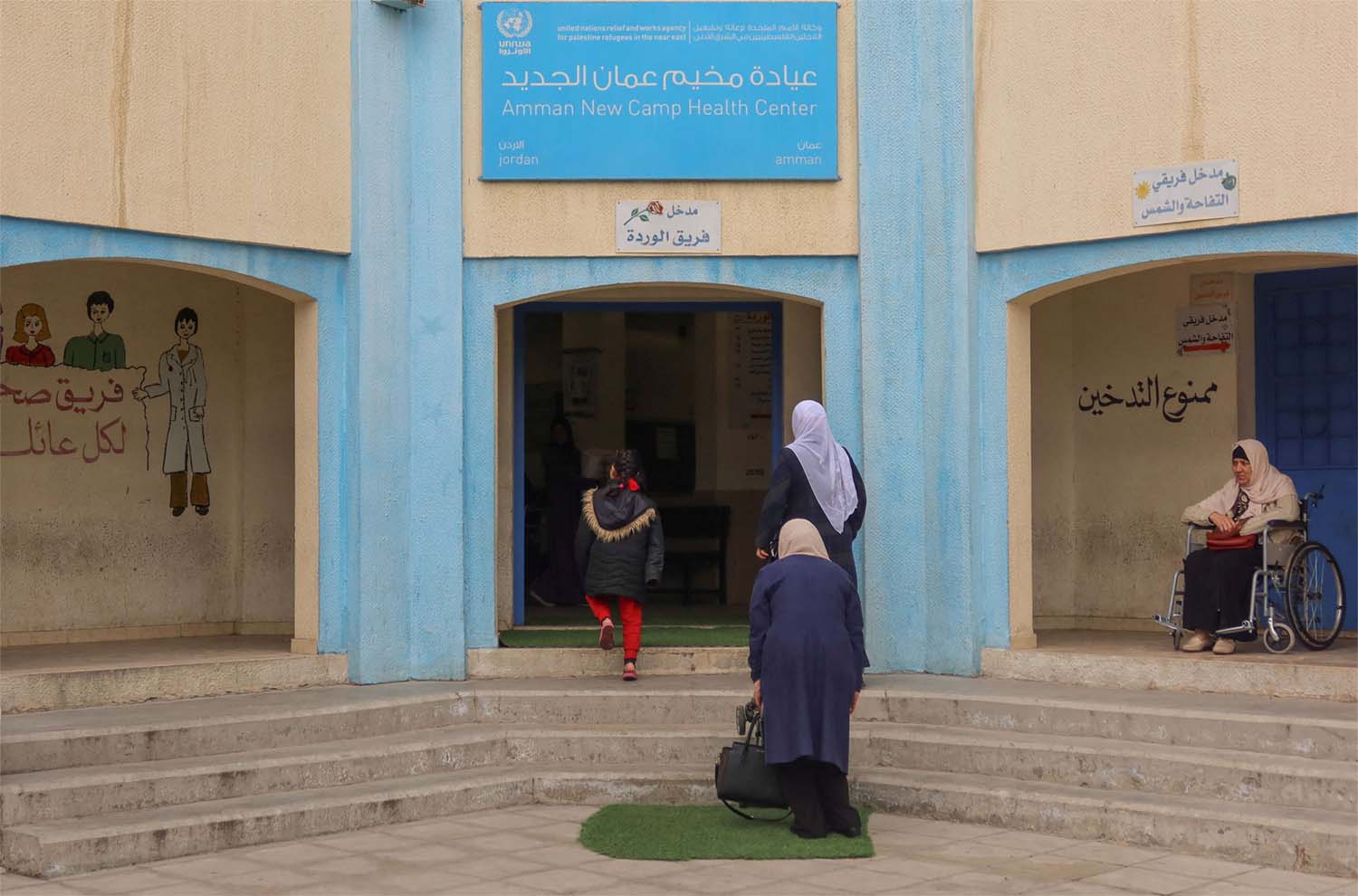 Women enter a health care center run by UNRWA at Amman new camp for Palestinian refugees