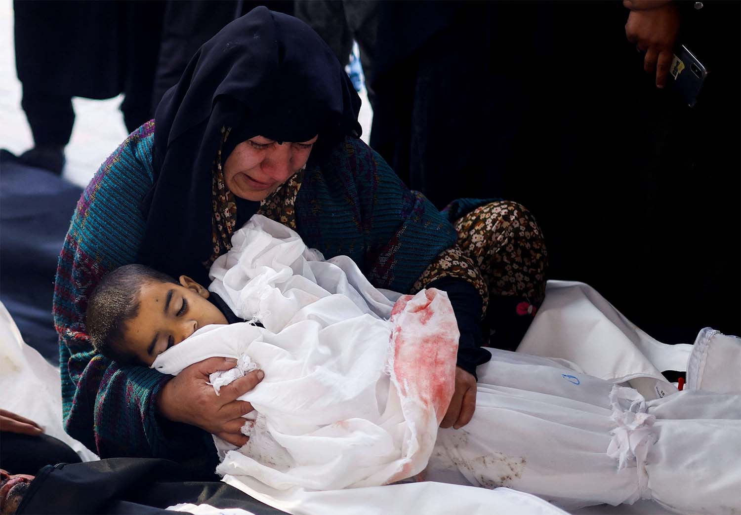  A Palestinian woman holds the body of a Palestinian child killed in Israeli strikes on Rafah