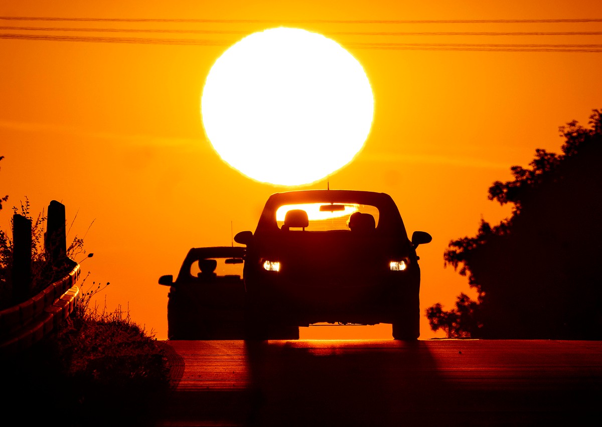 مشهد غروب شمس وراء سيارة