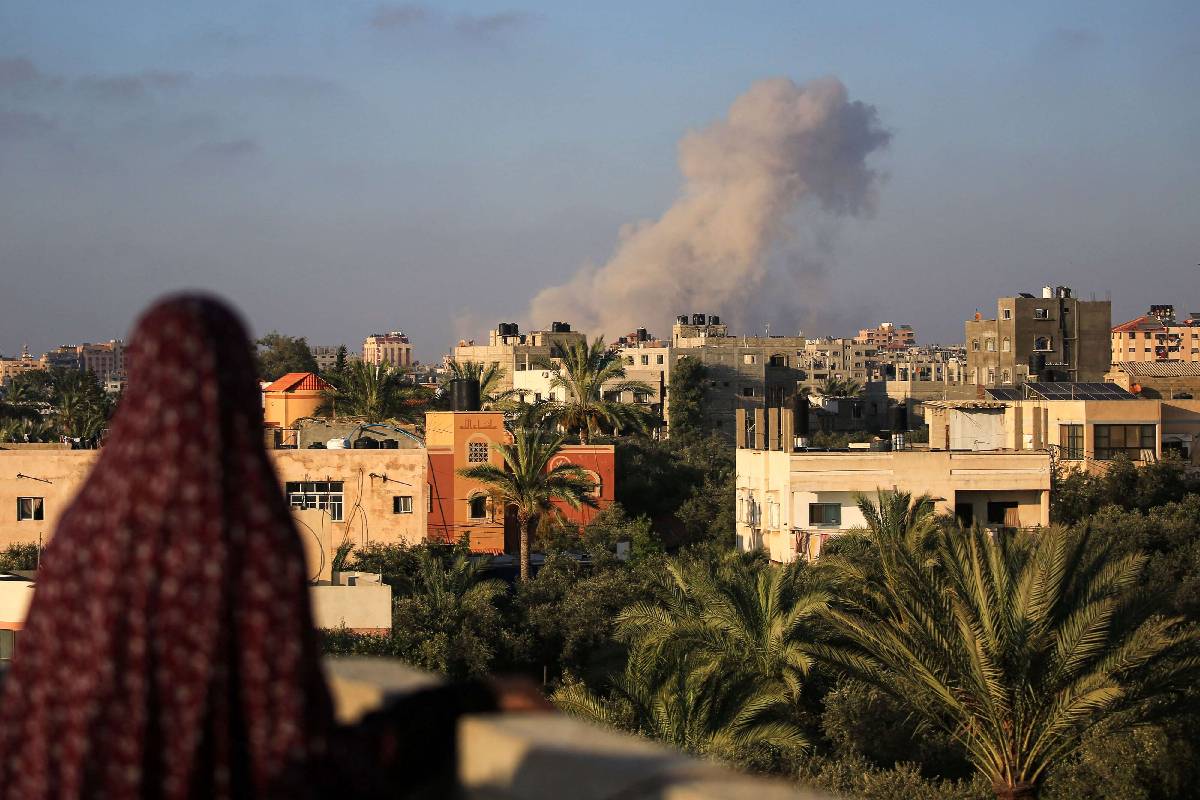 فلسطينية تنظر إلى قصف إسرائيلي وسط قطاع غزة