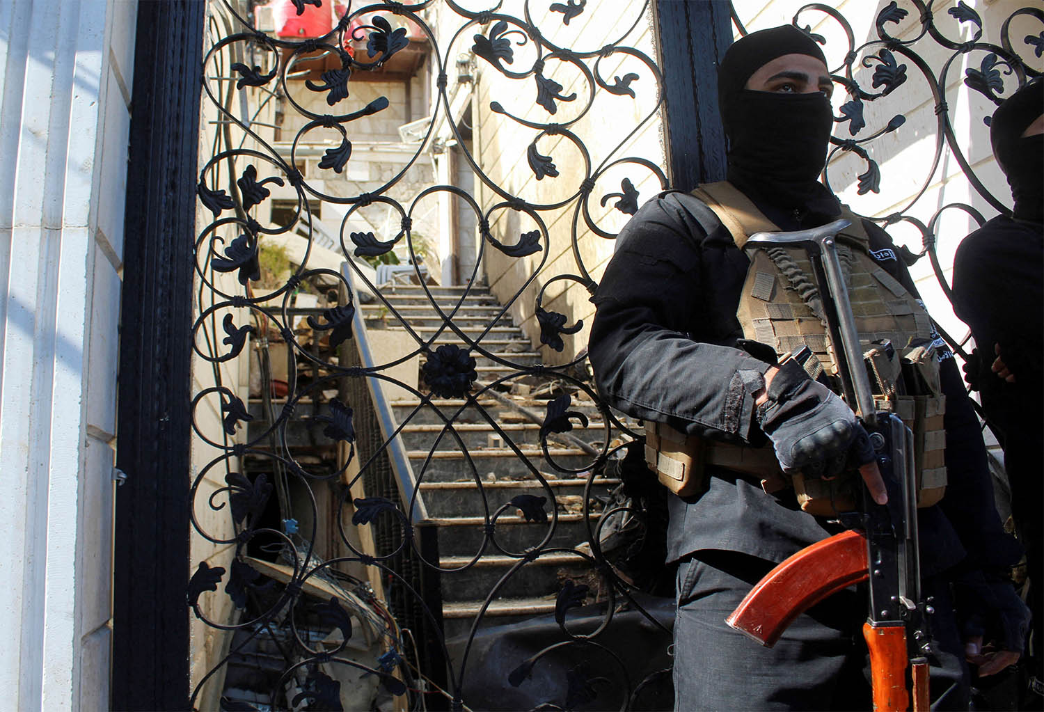 A member of Syrian security forces stands guard at a damaged site, after Israel carried out an air strike on Damascus
