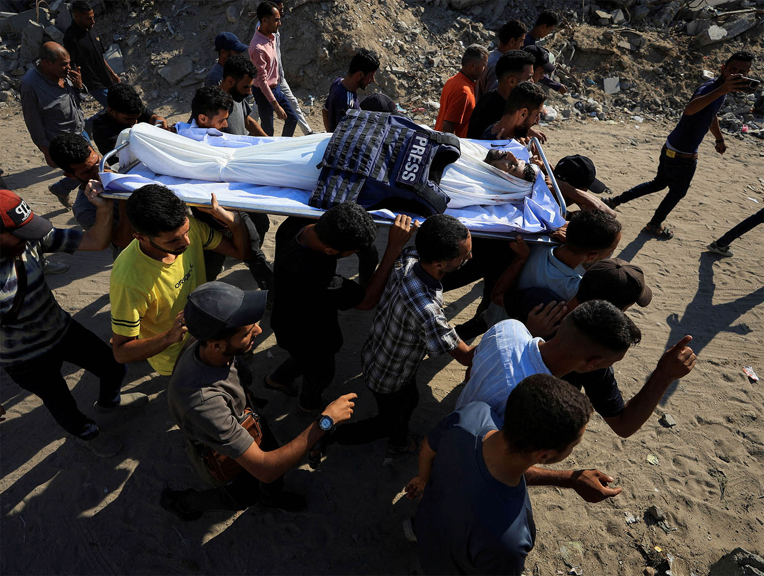 People carry the body of a Palestinian journalist, Adam Abu Harbid, killed in an overnight Israeli airstrike