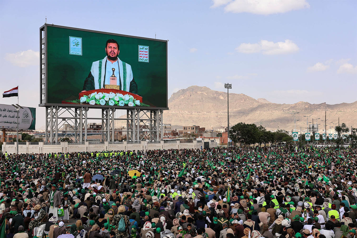 Abdul-Malik al-Houthi appears on a screen as people, mainly Houthi supporters, gather to mark the Prophet Muhammads birthday, at Sabeen Square in central Sanaa