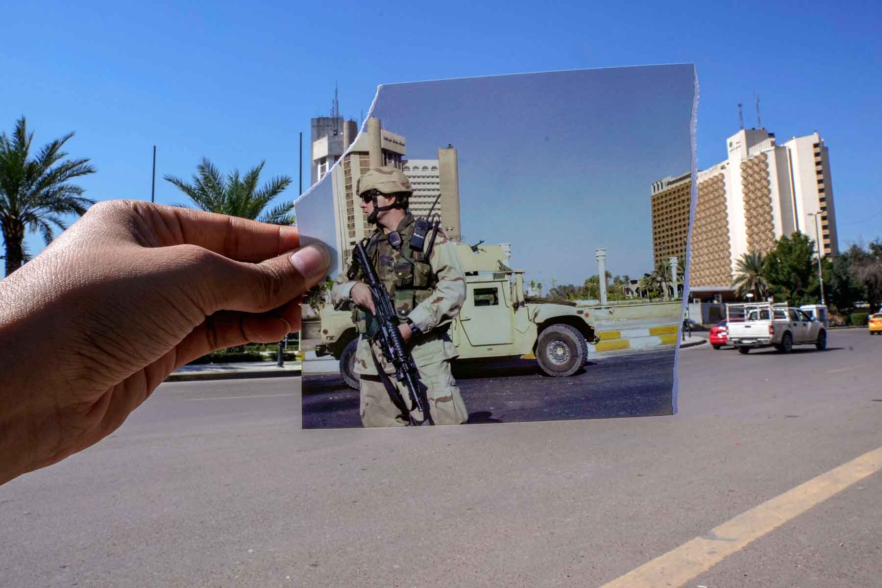 A photograph of a US soldier standing guard in Firdous square in front of the Sheraton (L) and Palestine hotels after they came under attack, July 2, 2004 is inserted into the scene at the same location, March 10, 2023.