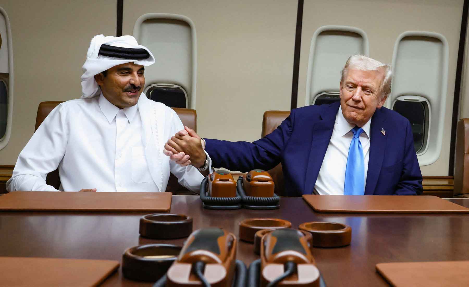 US President Donald Trump shakes hands with Qatar’s Emir Sheikh Tamim bin Hamad Al Thani during a meeting onboard Air Force One during its refuelling stop at Al Udeid Air Base near Doha, October 25, 2025. 