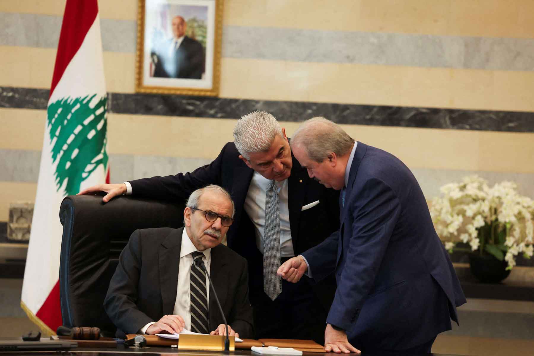 Lebanese Prime Minister Nawaf Salam speaks with Finance Minister Yassine Jaber and Lebanese Industry Minister Joe Issa el-Khoury during a cabinet meeting in Beirut, December 23, 2025. 