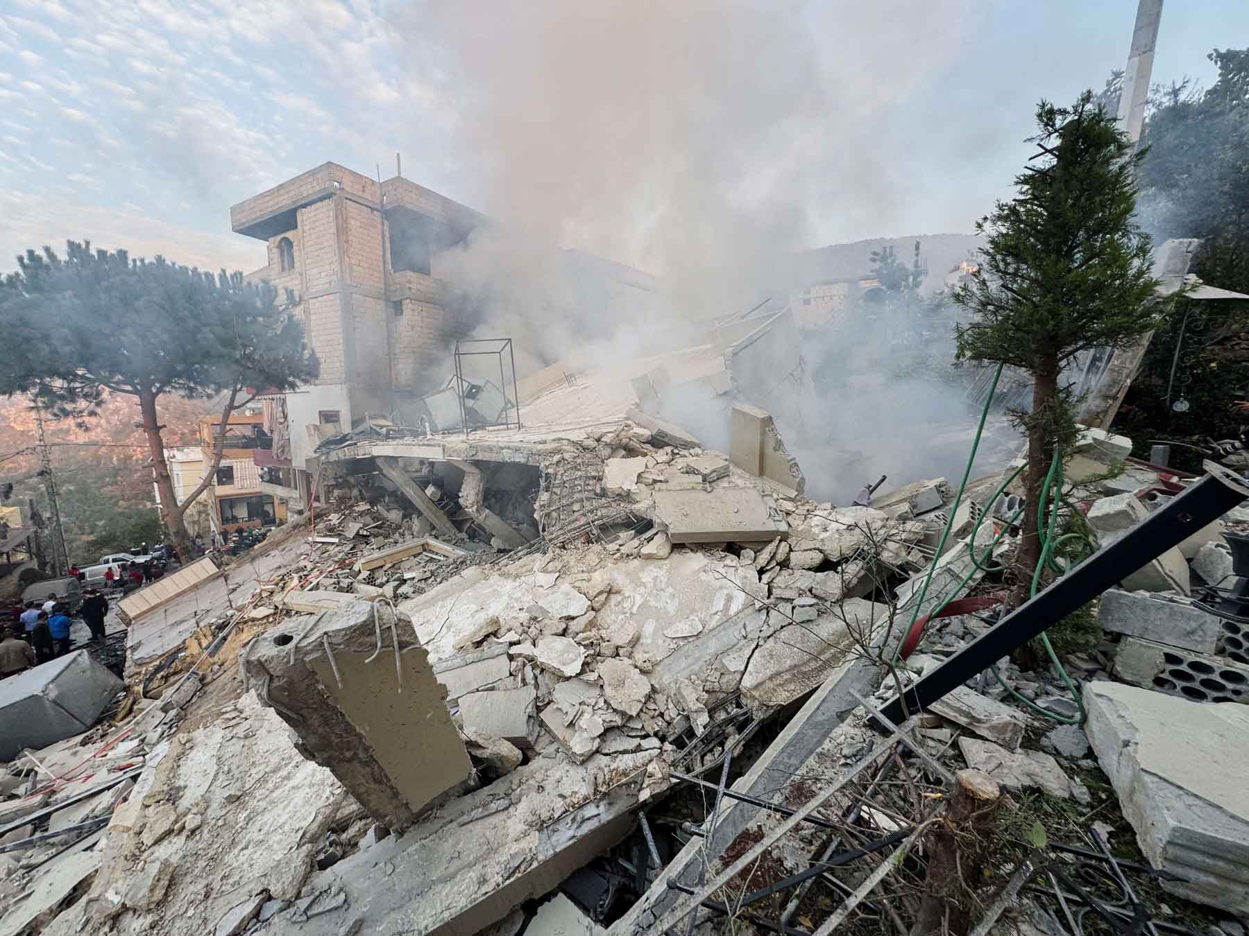 People inspect a damaged site after Israel’s military said it struck targets in two southern Lebanese towns, December 4, 2025. 