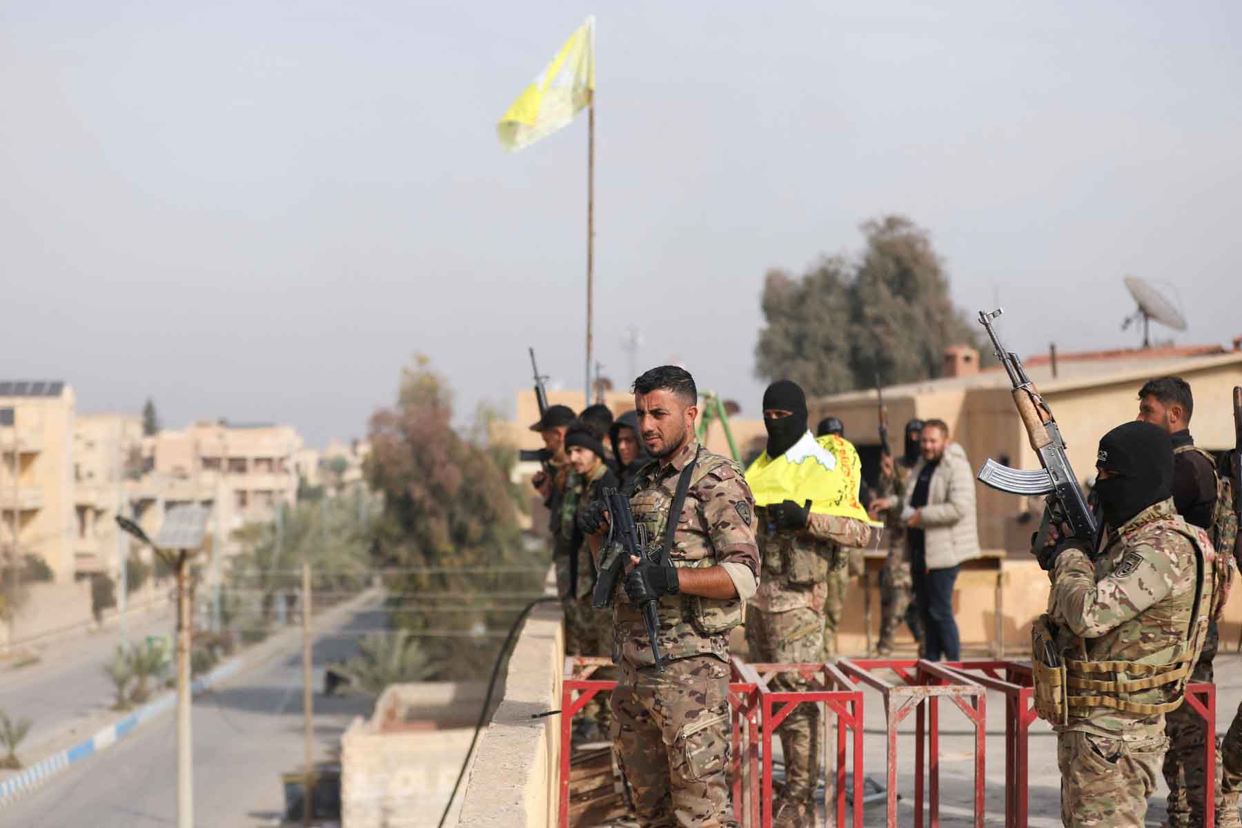 Members of the Kurdish-led Syrian Democratic Forces (SDF) hold weapons in Deir ez-Zor, December 7, 2024. 