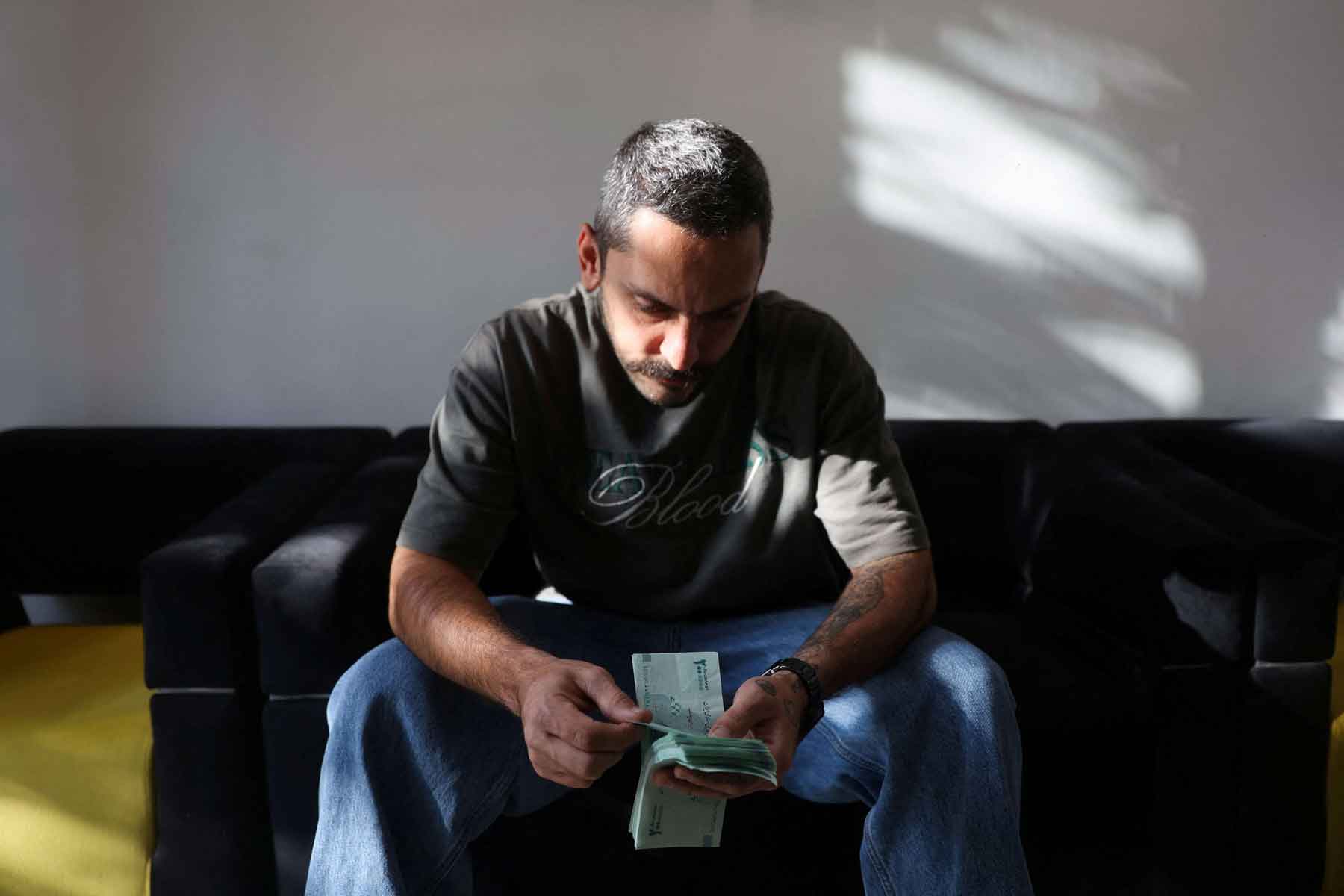 A currency dealer holds Iranian rial bills in Tehran.