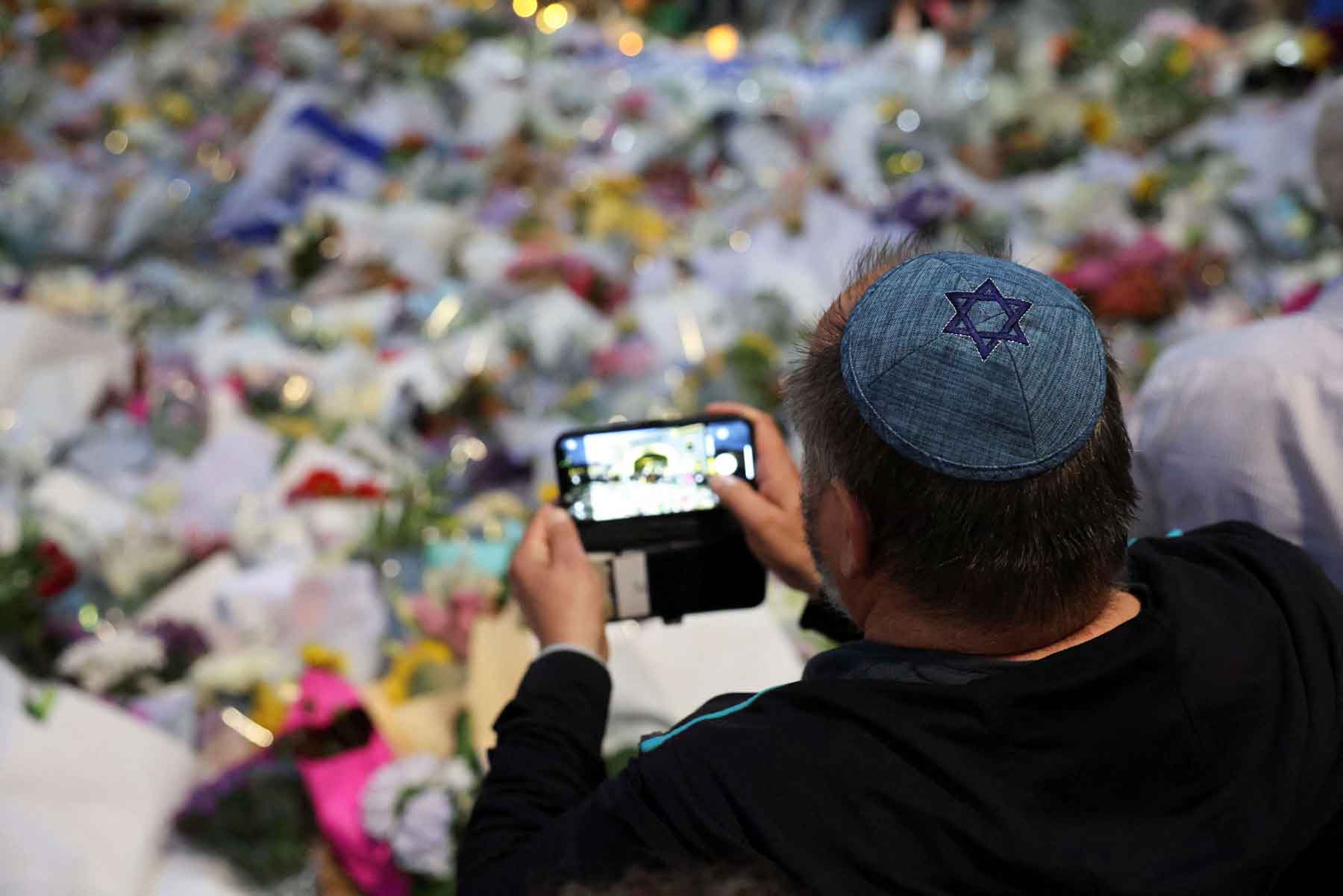 A man wearing a kippah with a Star of David on it pays his respects at Bondi Pavilion to victims of a shooting during a Jewish holiday celebration at Bondi Beach, in Sydney, December 15, 2025. 