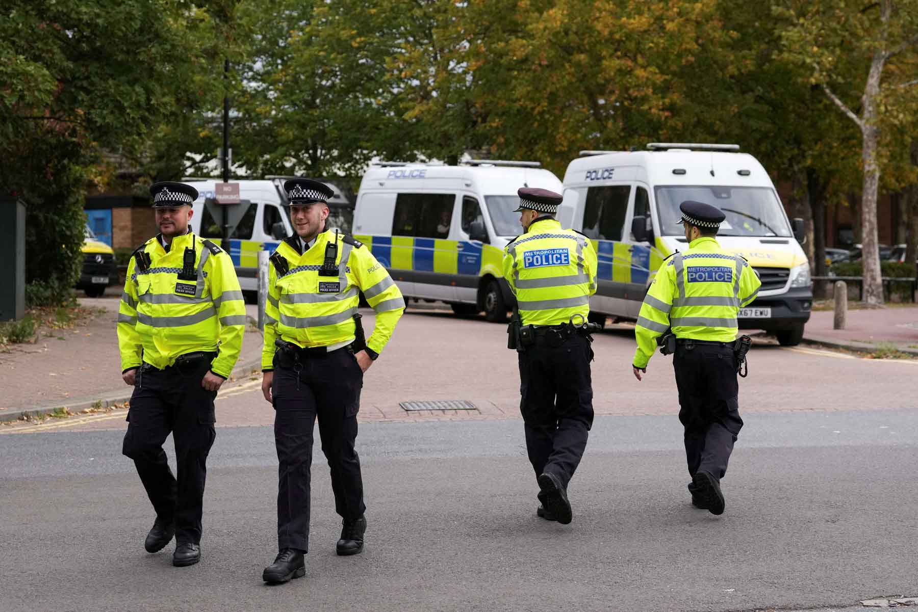 Police officers walk outside a court building in London.