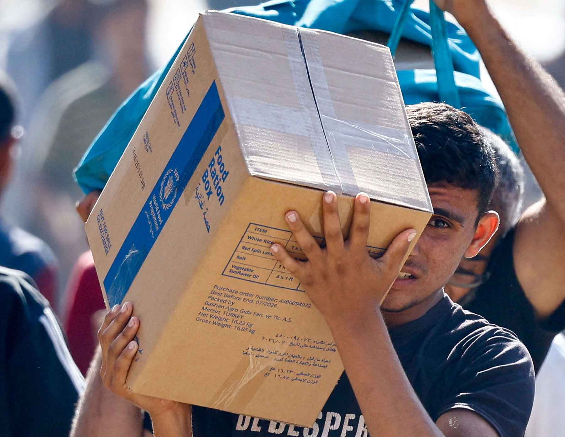  A Palestinian carries aid supplies that entered Gaza in Zawaida in the central Gaza Strip, October 21, 2025. 