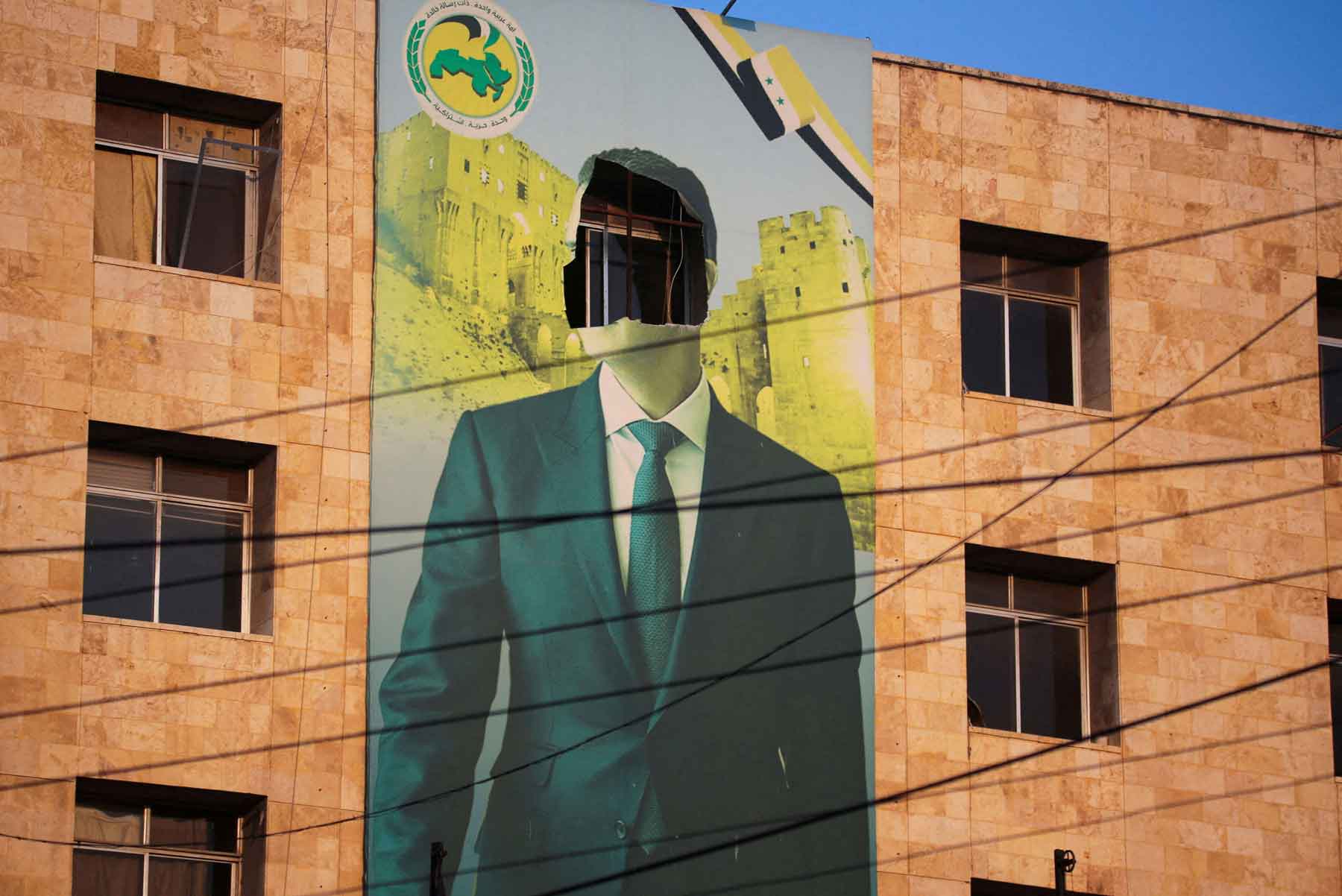 A damaged poster of Syria’s former president Bashar al-Assad in Aleppo, November 30, 2024. 