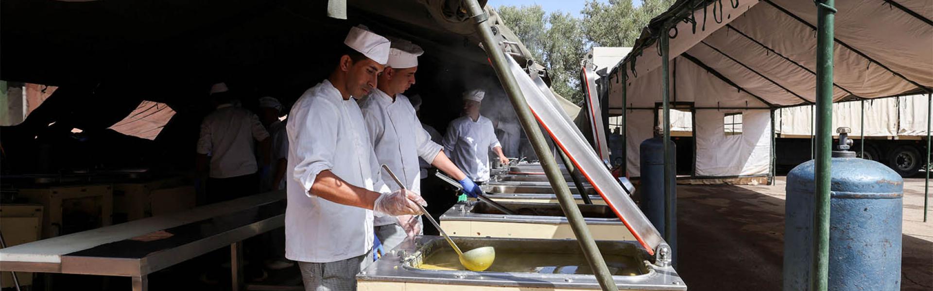 en prepare meals for displaced people residing in a military aid camp following the deadly earthquake in Amizmiz in September 2023